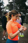 Mujer deportista revisando su reloj Suunto durante un entrenamiento al aire libre.